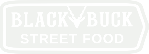 Logo featuring bold, uppercase letters on a white background within an oval border that points right , with a stylised image of a deer's head and antlers centred above the text, which reads 'STREET FOOD'.