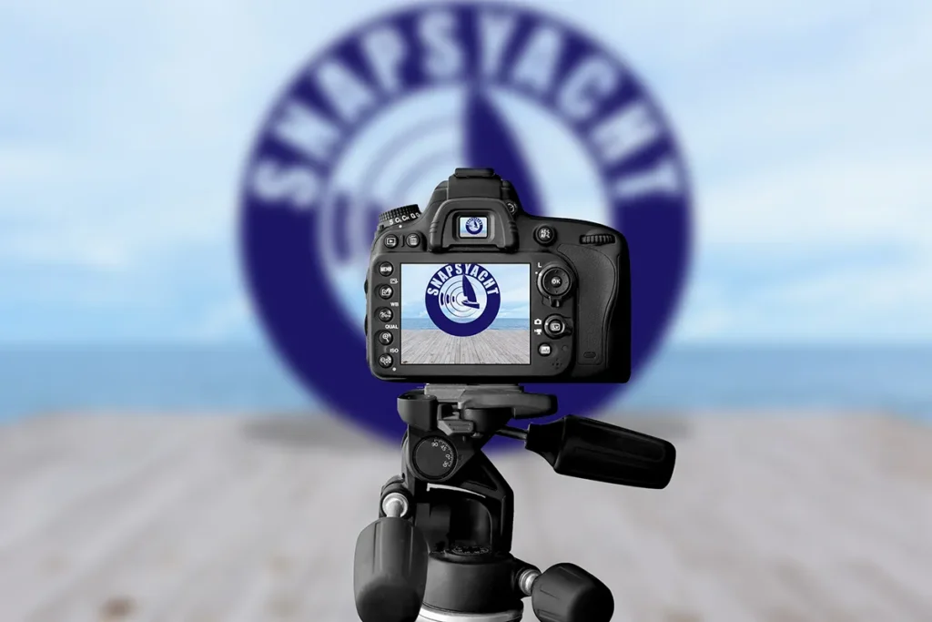Camera on tripod capturing a sharp logo while a blurred version appears in the background, emphasizing focus and branding.