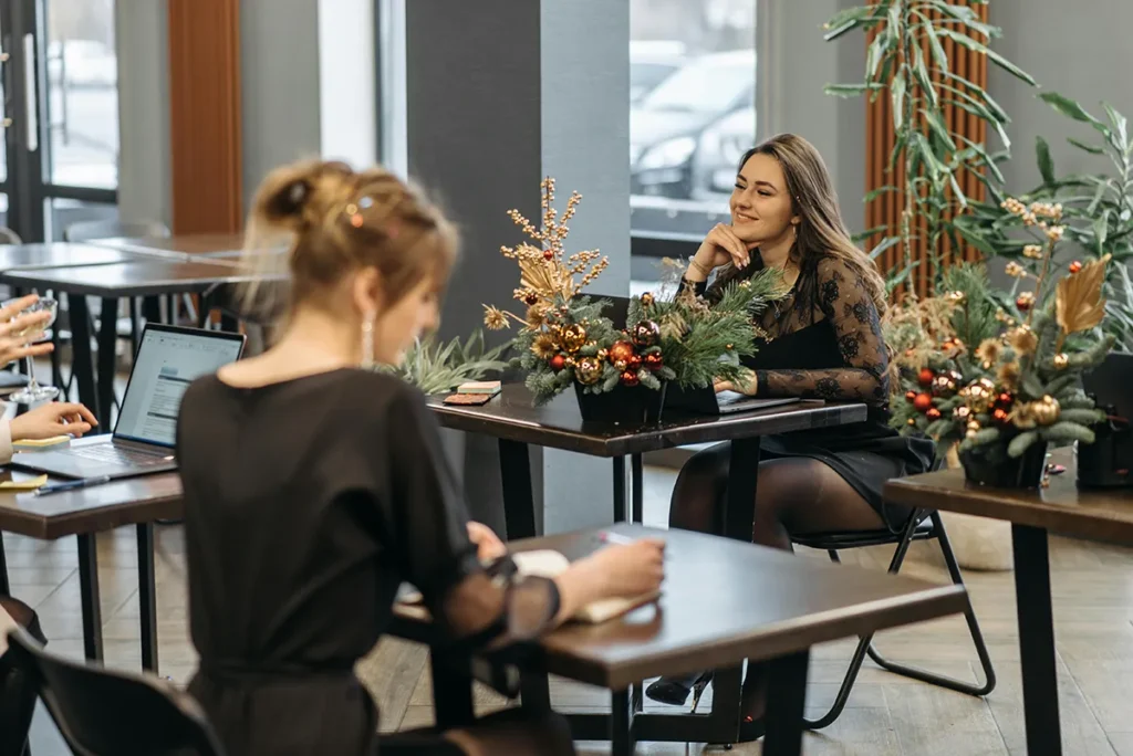 Small business owners meeting in a café workspace, reflecting reflection, planning, and end-of-year business conversations