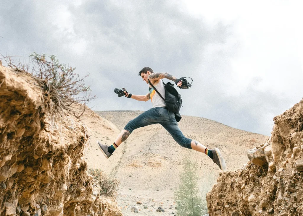 Entrepreneur jumping across a gap outdoors, representing bold decision-making and business growth