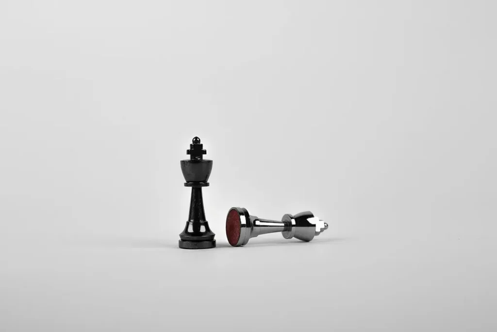 Black chess king standing beside a fallen piece, symbolising strategic reflection and branding design decisions in business